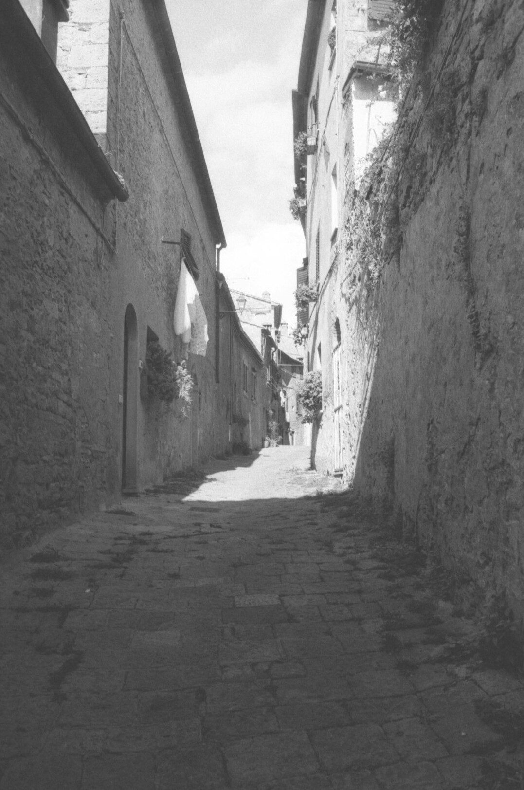 Documentary photographer taking a photo on a cobblestone street in a small town