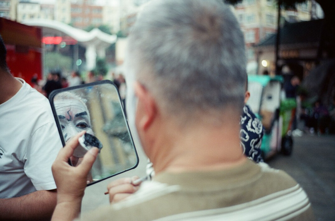 Photographer interviewing an elderly man with a notebook and recorder
