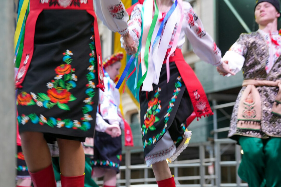 People in traditional Polish folk costumes dancing at a festival