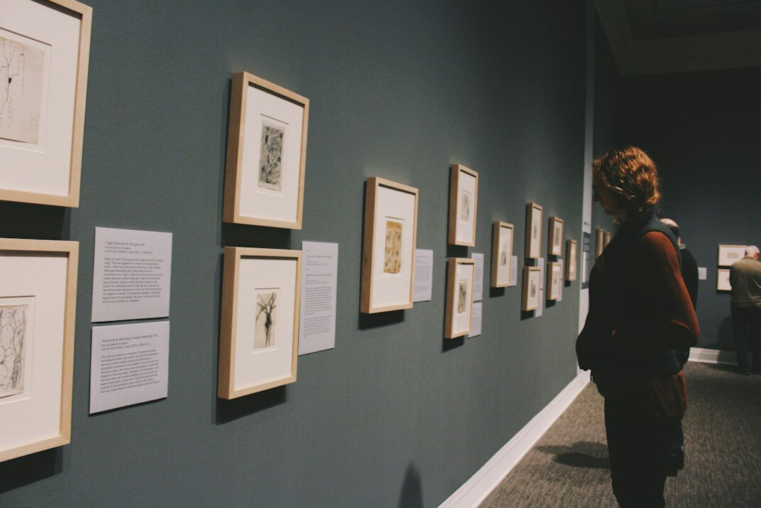 Visitors looking at framed documentary photographs in a gallery
